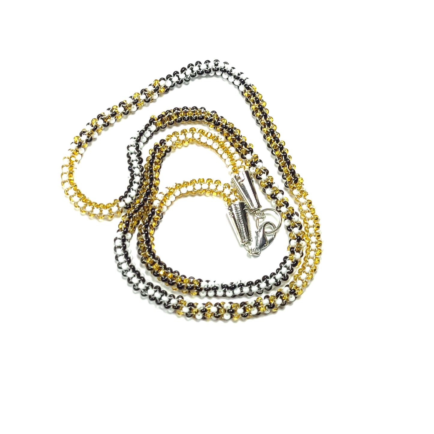 Necklace made of white, black, and gold colored seed beads with silver colored end caps and clasp.