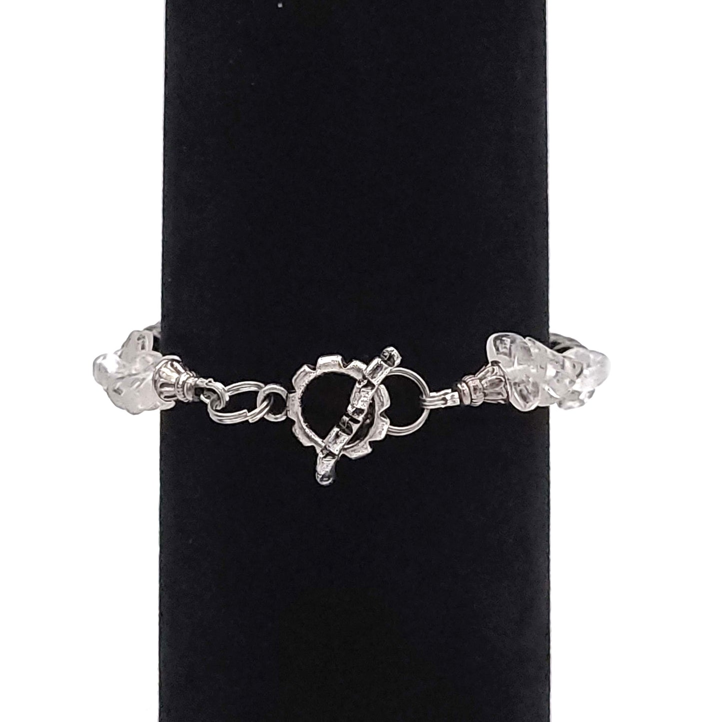 Toggle clasp of a black and crystal bead bracelet on a black velvet diaplay.