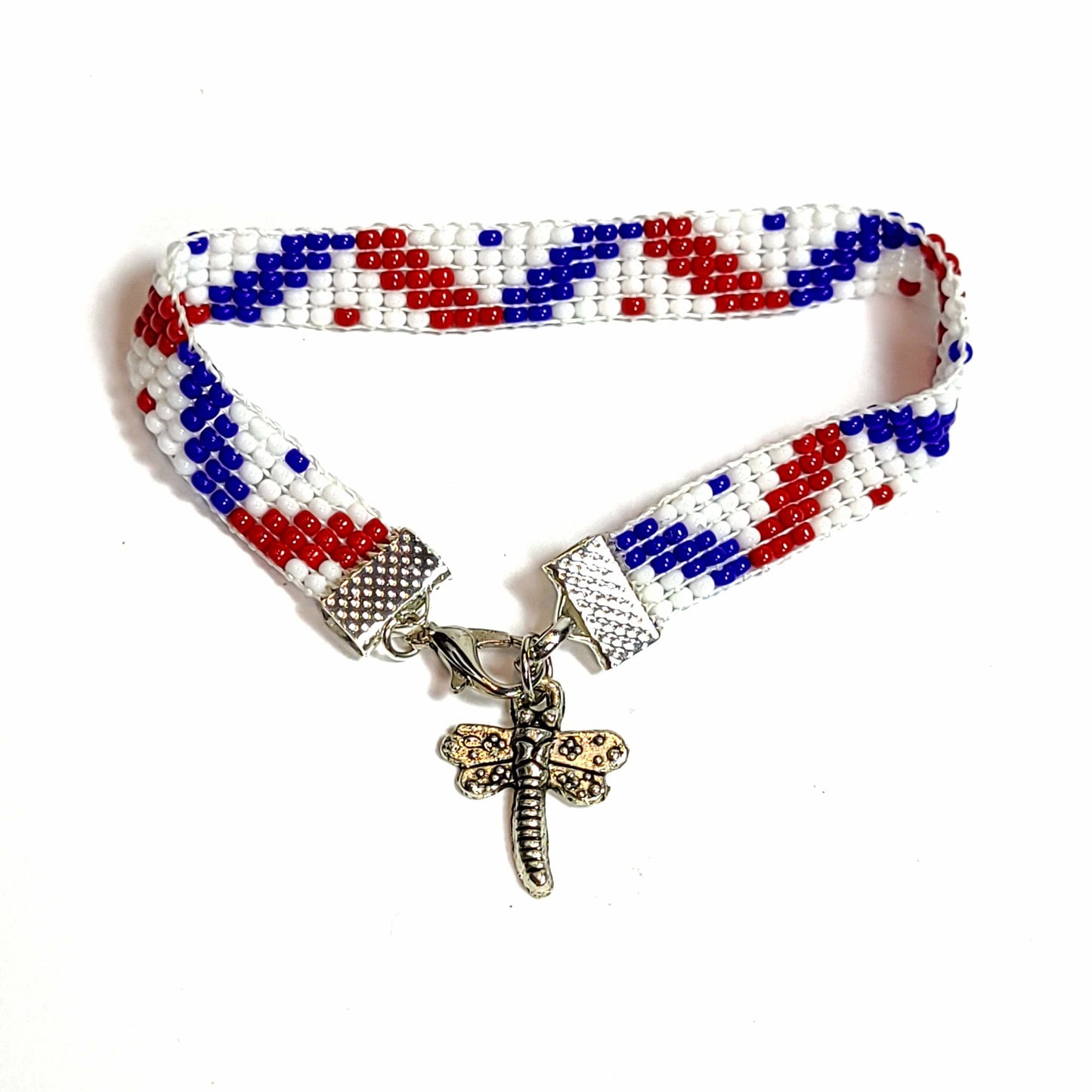 Woven seed bead bracelet with red, white, and blue seed beads. Silver toned end clips with silvertoned lobster clasp and silvertoned dragonfly charm.