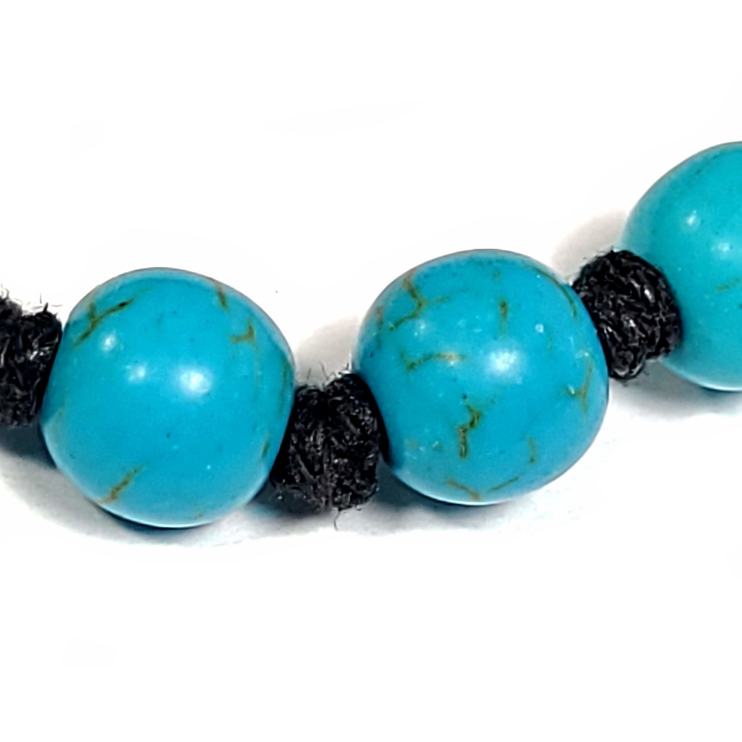 Close up view of a handmade knotted blue turquoise dyed Howlite Bracelet/Anklet. Adjustable slip knot makes easy size adjustment.