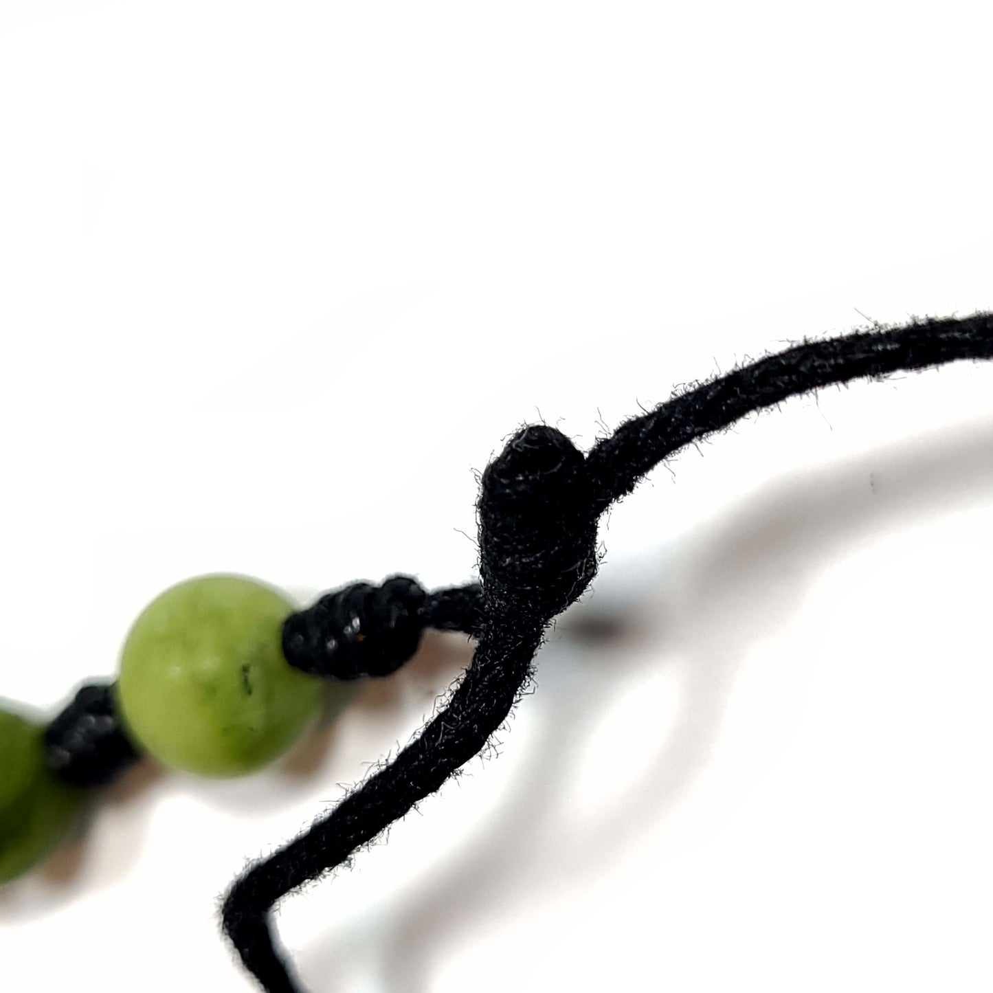 Close up of the adjustable slip knot on a handmade knotted multi-colored Quartz beaded bracelet/anklet with an adjustable slip knot.