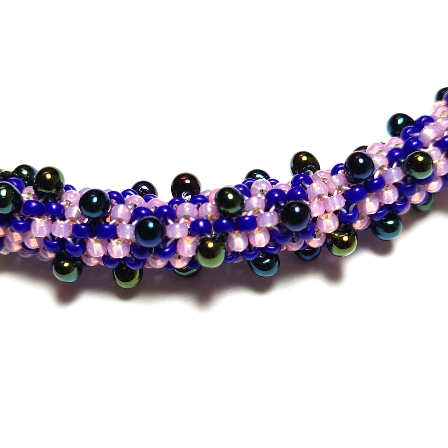 close up of bracelet made of lilac, purple, royal blue, and iridescent black beads