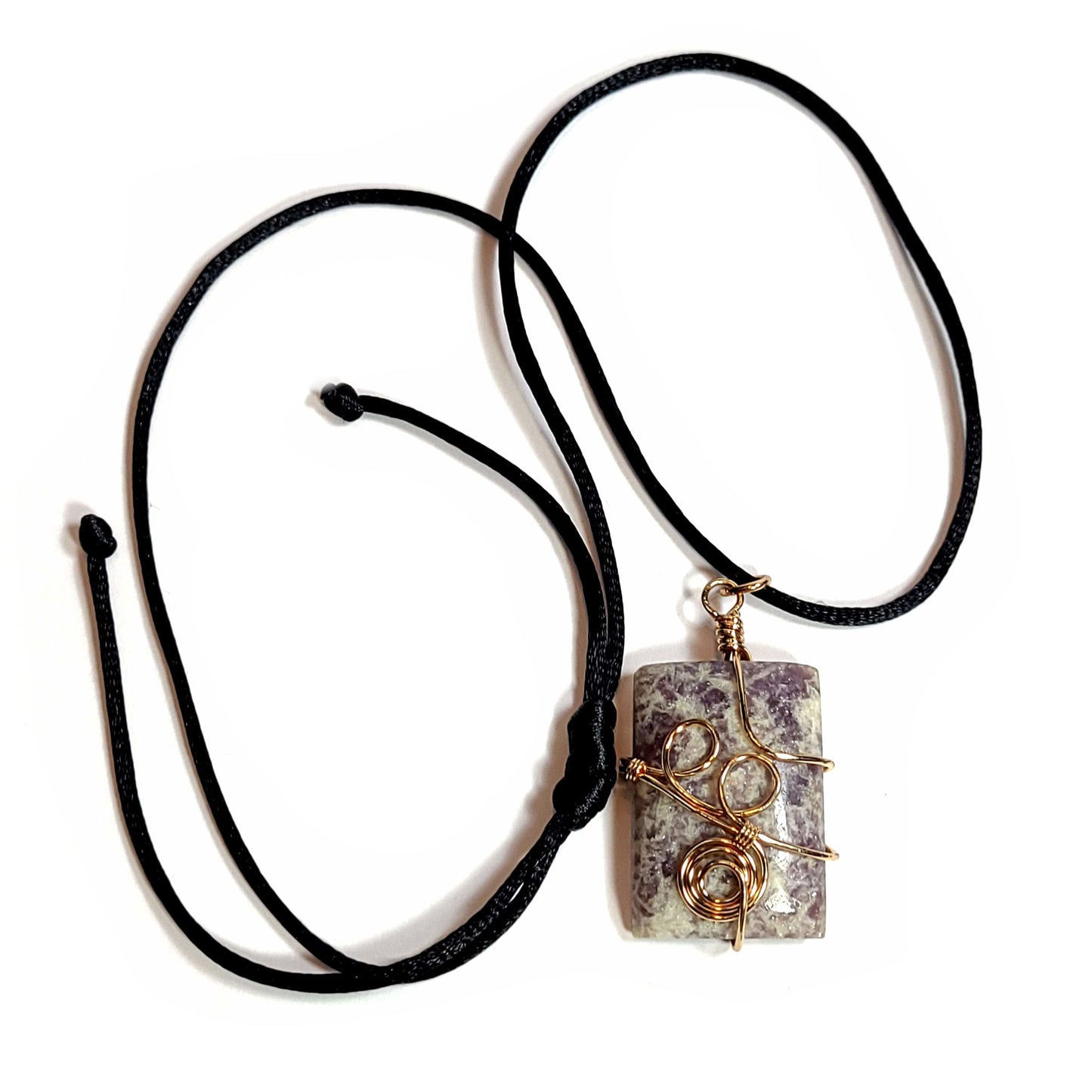 Rose gold colored wire wrapped Purple and White Fluorite. Comes with a black satin cord with an adjustable slip knot.