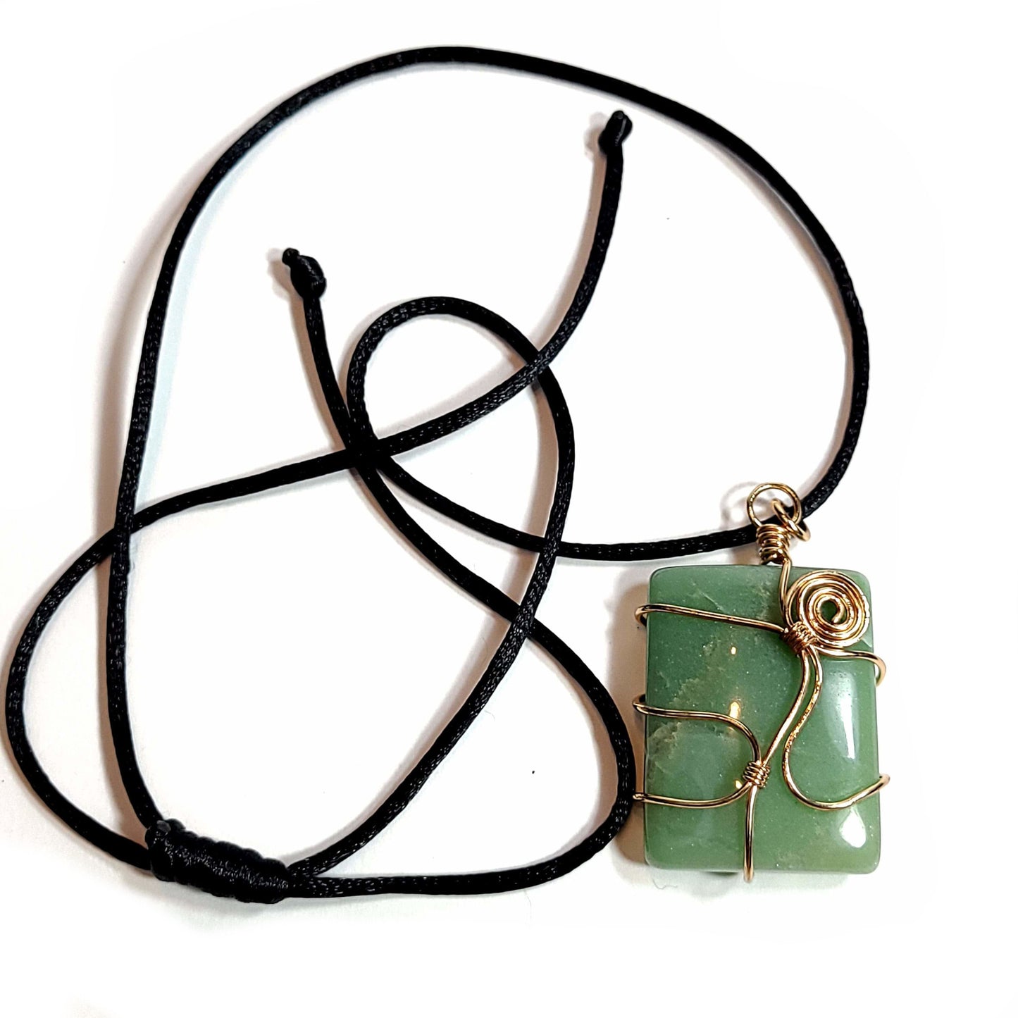 Rose gold colored wire wrapped Jade pendant with a black satin cord about with an adjustable slip knot.