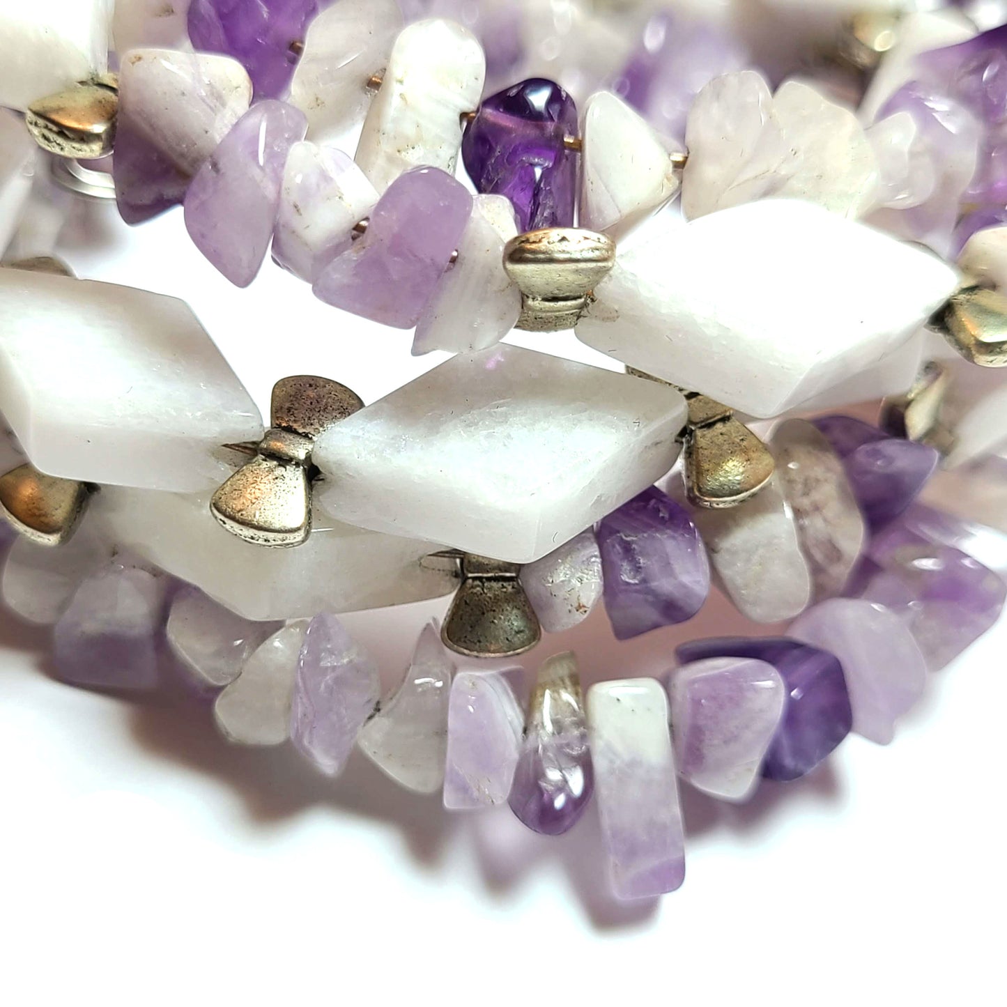 Close up of amethyst chips, triangle beads, and silver bows wrapping bracelet.