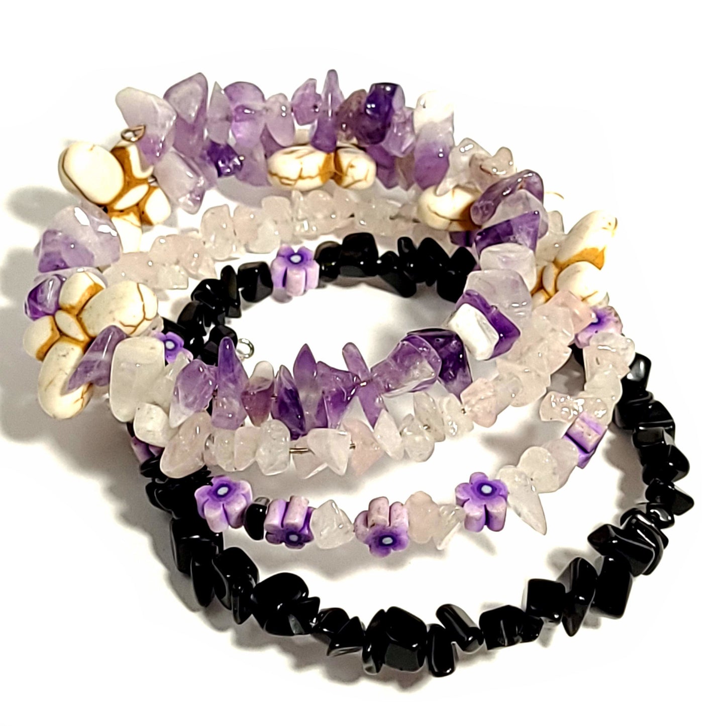memory wire bracelet with shiny black beads, rose quartz chip beads, quartz chip beads, butterfly beads, and amethyst chip beads.