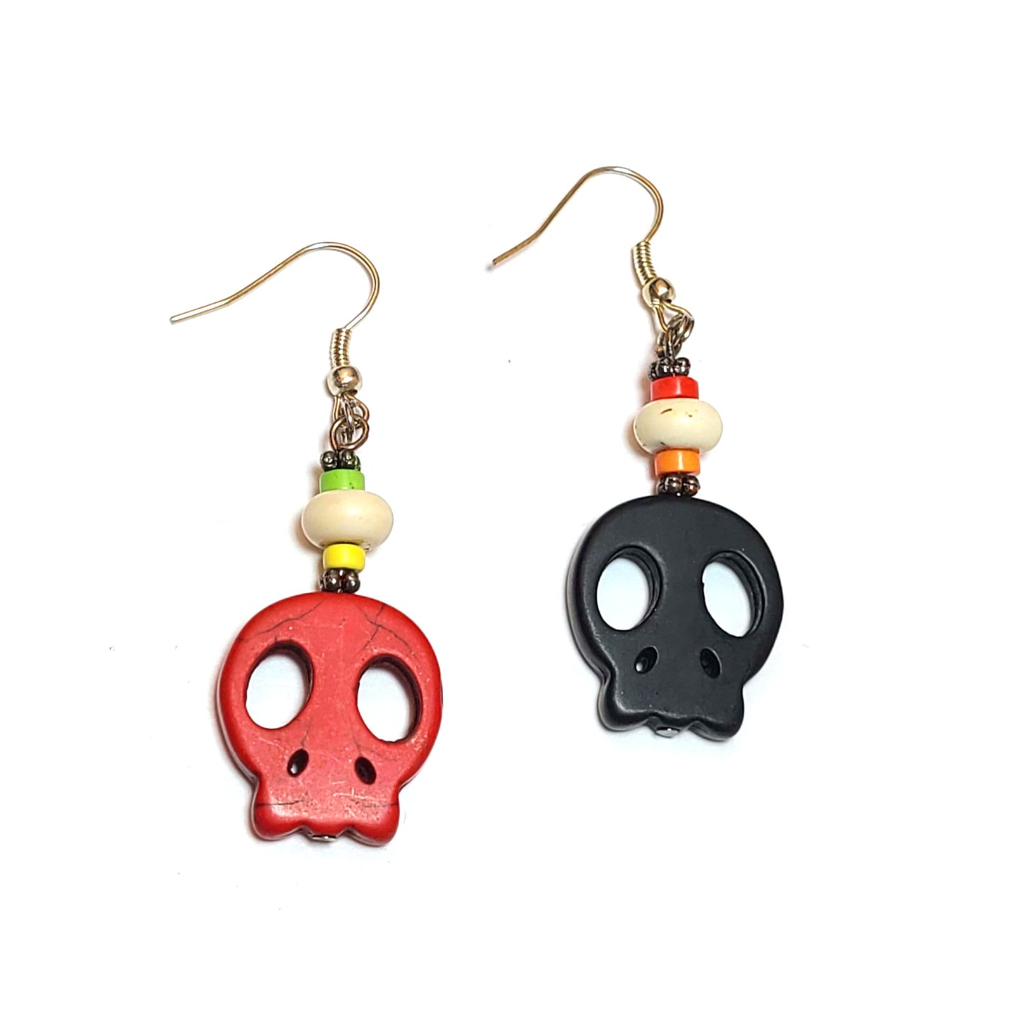 Skull earrings, one red and one black with decorative beads above the skulls