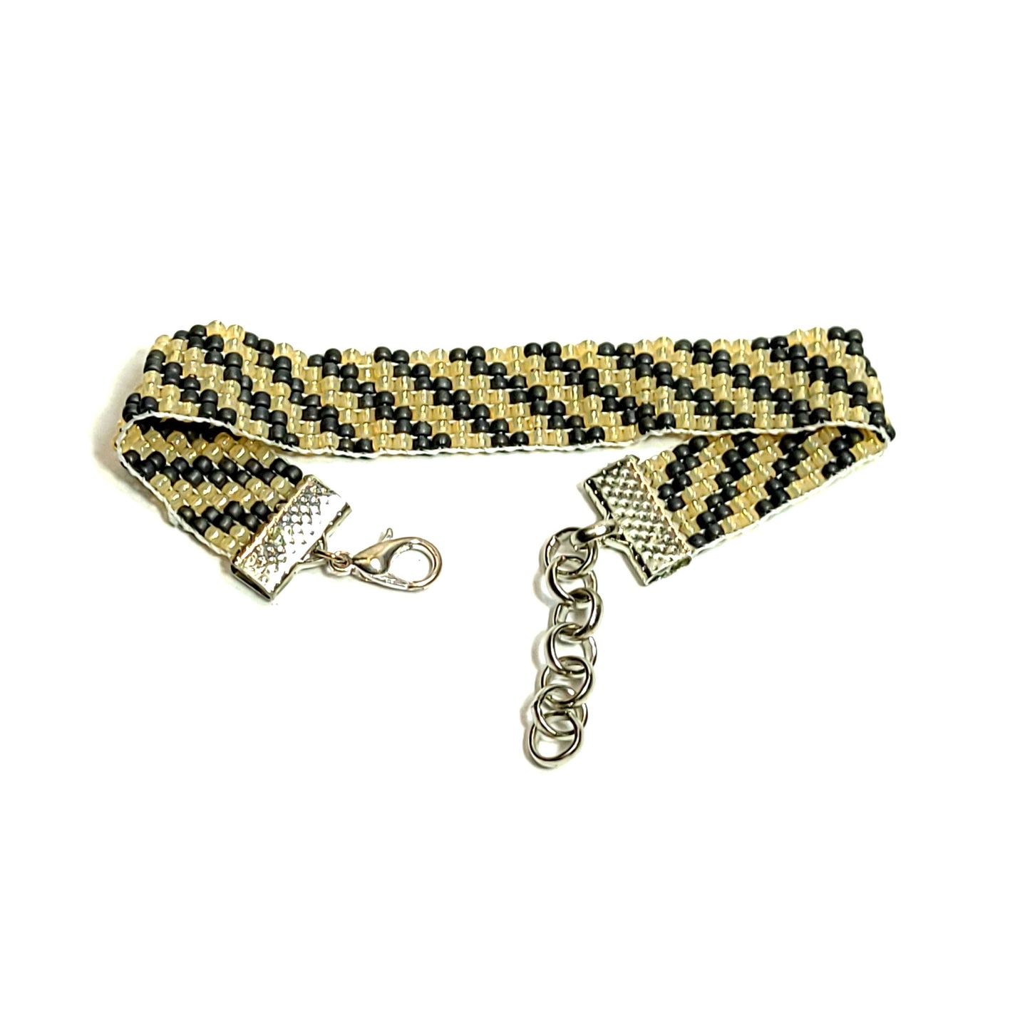 Classic looking unisex bracelet made with black and gold color seed beads with a diagonal striped pattern. It has an extender chain