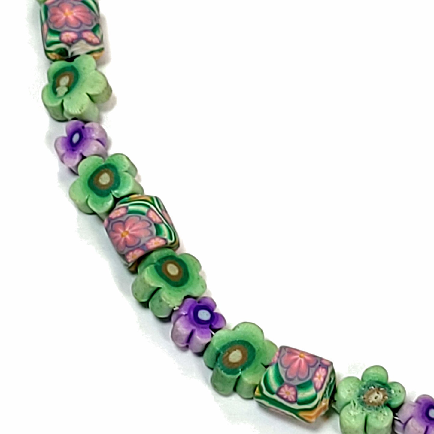Close up of Green and purple floral polymer bead necklace.