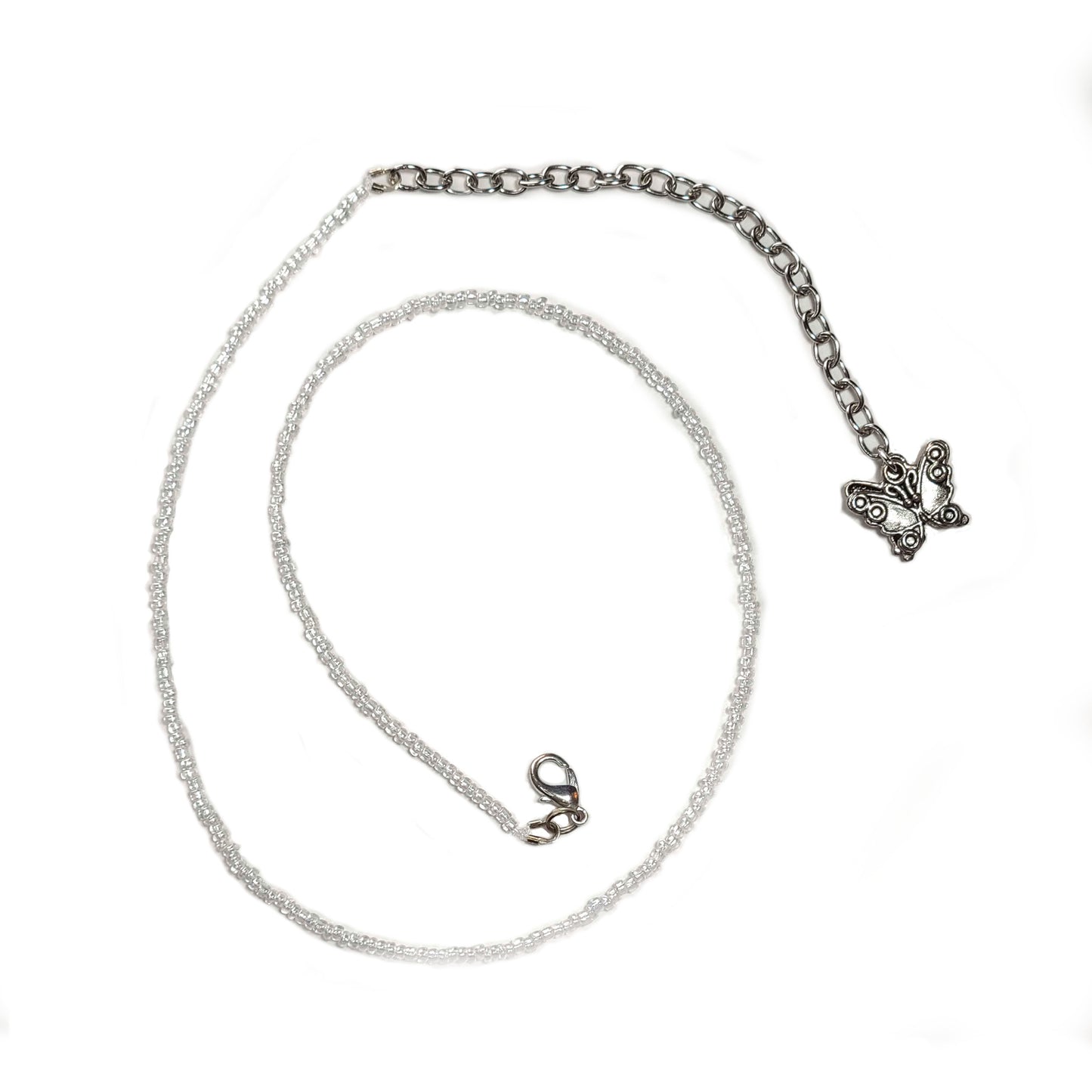 Single strand silver colored seed bead necklace with an extender that has 2 butterfly charms on the end.