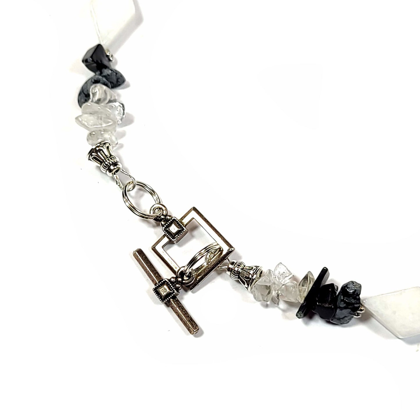 Necklace made of White quartz diamond beads, with crystal quartz chips and Snowflake Obsidian highlighted with silver tone spacer beads and bar and loop toggle clasp. Clasp view.