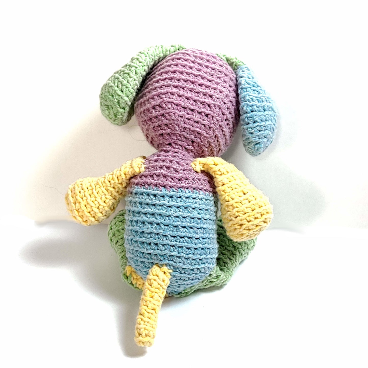 Back view of Multi-color hand crocheted puppy stuffie. Yellow, green, blue, lavender.