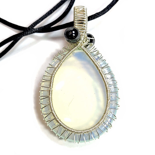 Silver toned wire wrapped Opalite. Comes with a black satin cord with an adjustable slip knot. This stone does have some specks and a scratch, but has very interesting color that really pops, especially on top of dark colors.