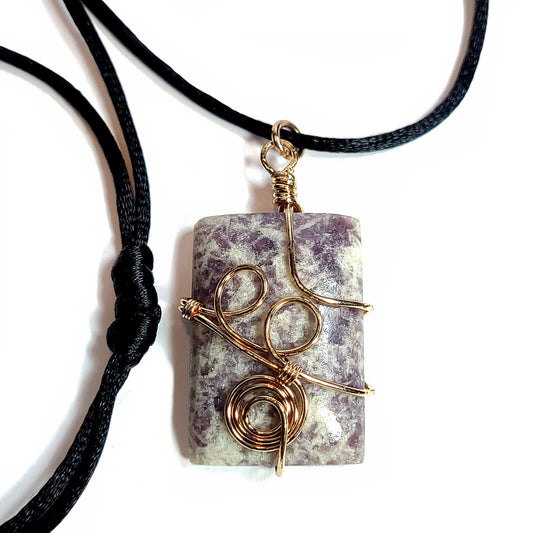 Rose gold colored wire wrapped Purple and White Fluorite. Comes with a black satin cord with an adjustable slip knot.