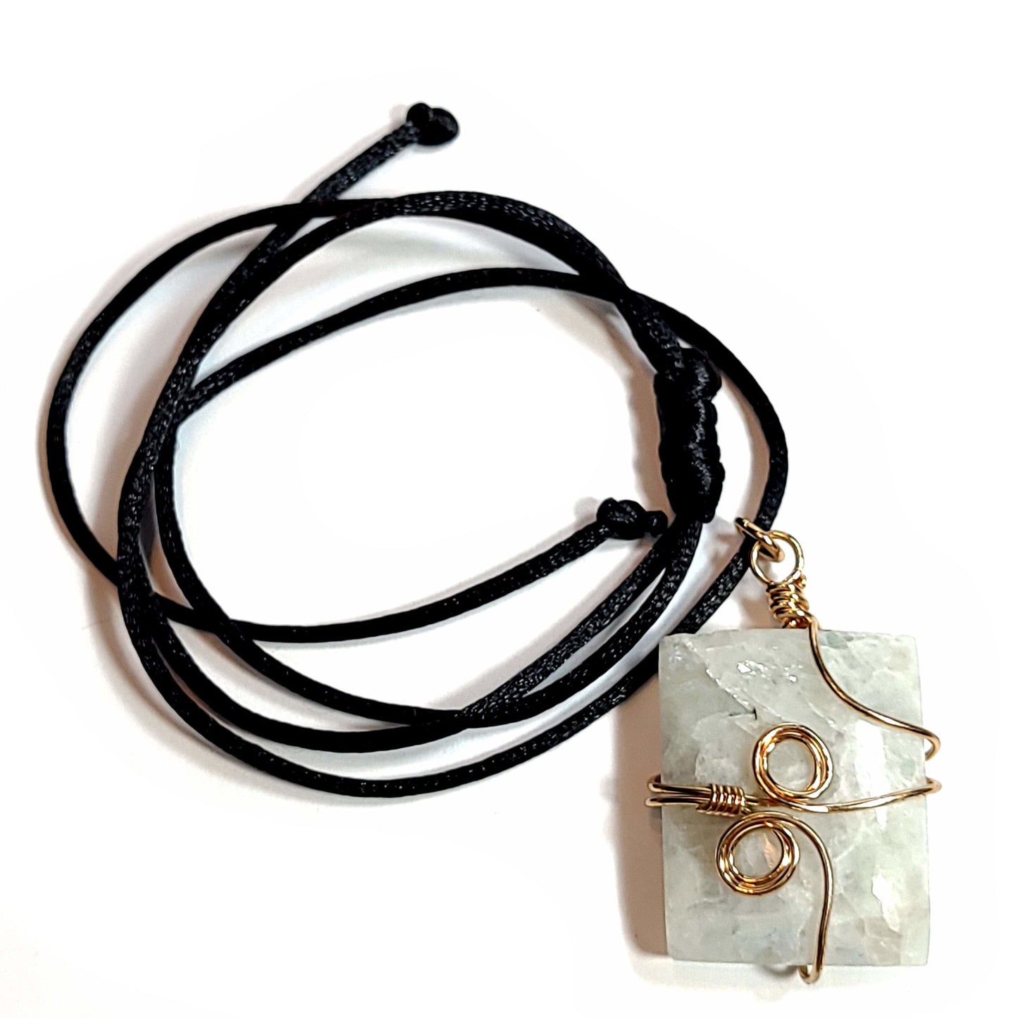 Rose wire wrapped Quartz pendant with tiny bits of black Tourmaline. Comes with a black satin cord with an adjustable slip knot. Stone has some minor natural pits and has a slight chip in the upper left corner.
