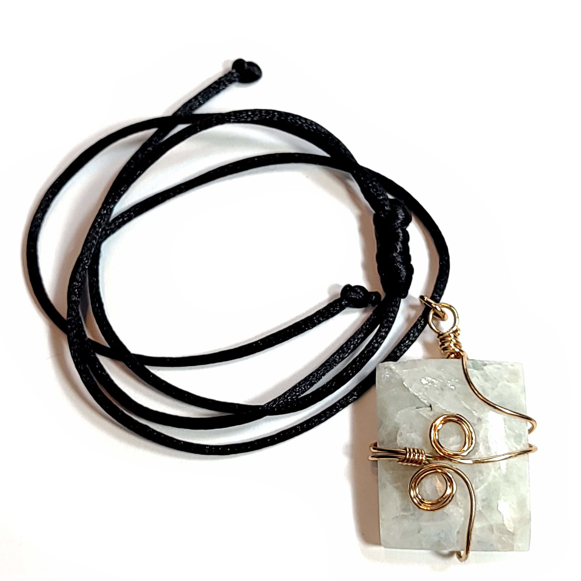 Rose wire wrapped Quartz pendant with tiny bits of black Tourmaline. Comes with a black satin cord with an adjustable slip knot. Stone has some minor natural pits and has a slight chip in the upper left corner.