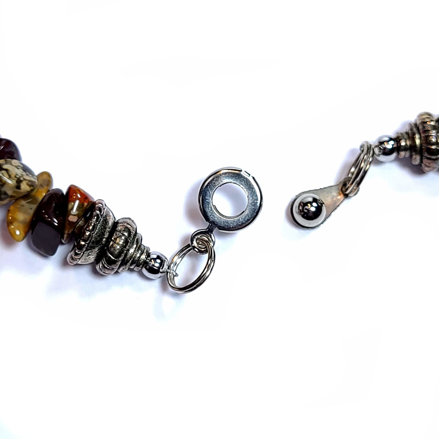 Open clasp of a handmade Necklace with vintage shells, jasper chip beads, and 5 10mm turquoise dyed beads.