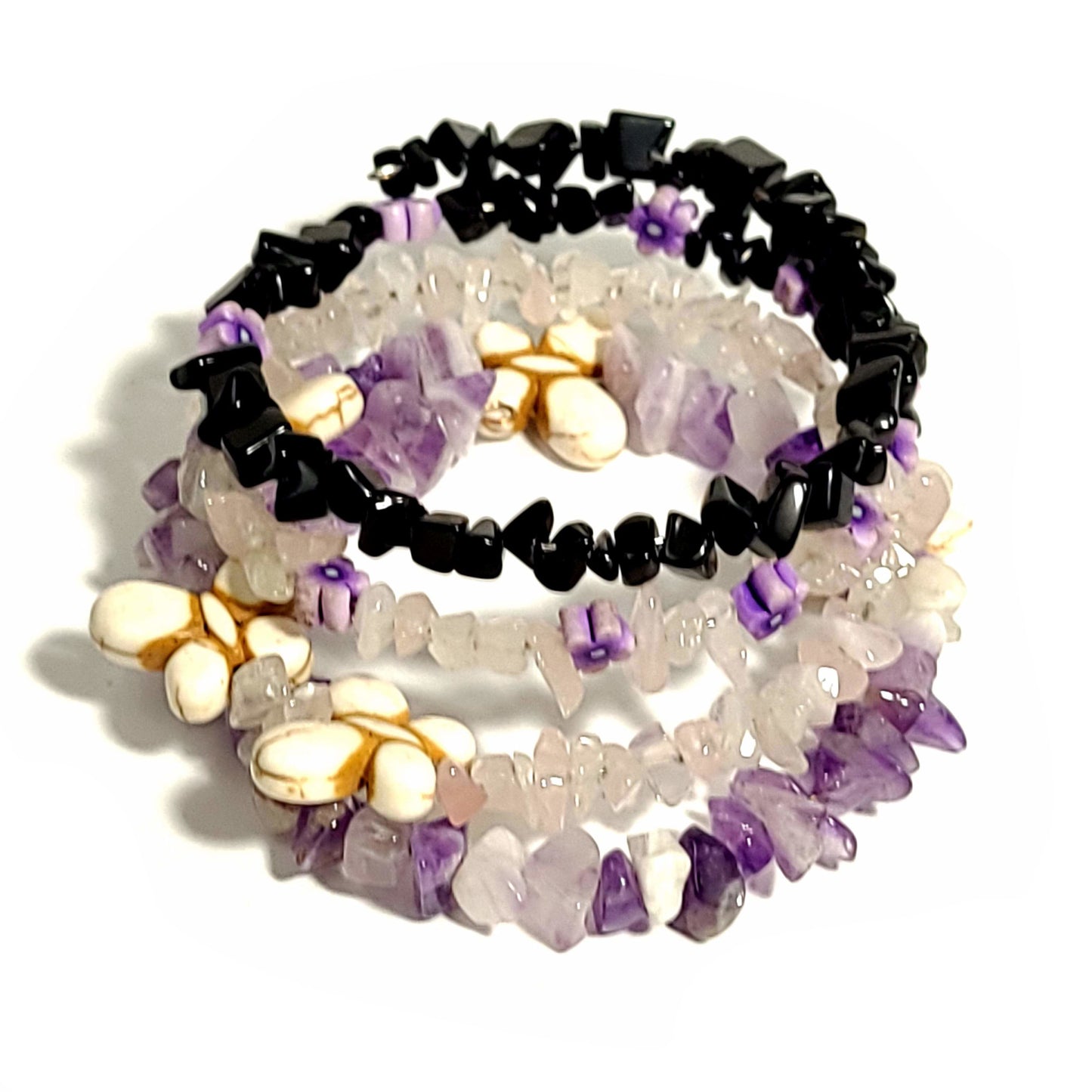 memory wire bracelet with shiny black beads, rose quartz chip beads, quartz chip beads, butterfly beads, and amethyst chip beads.