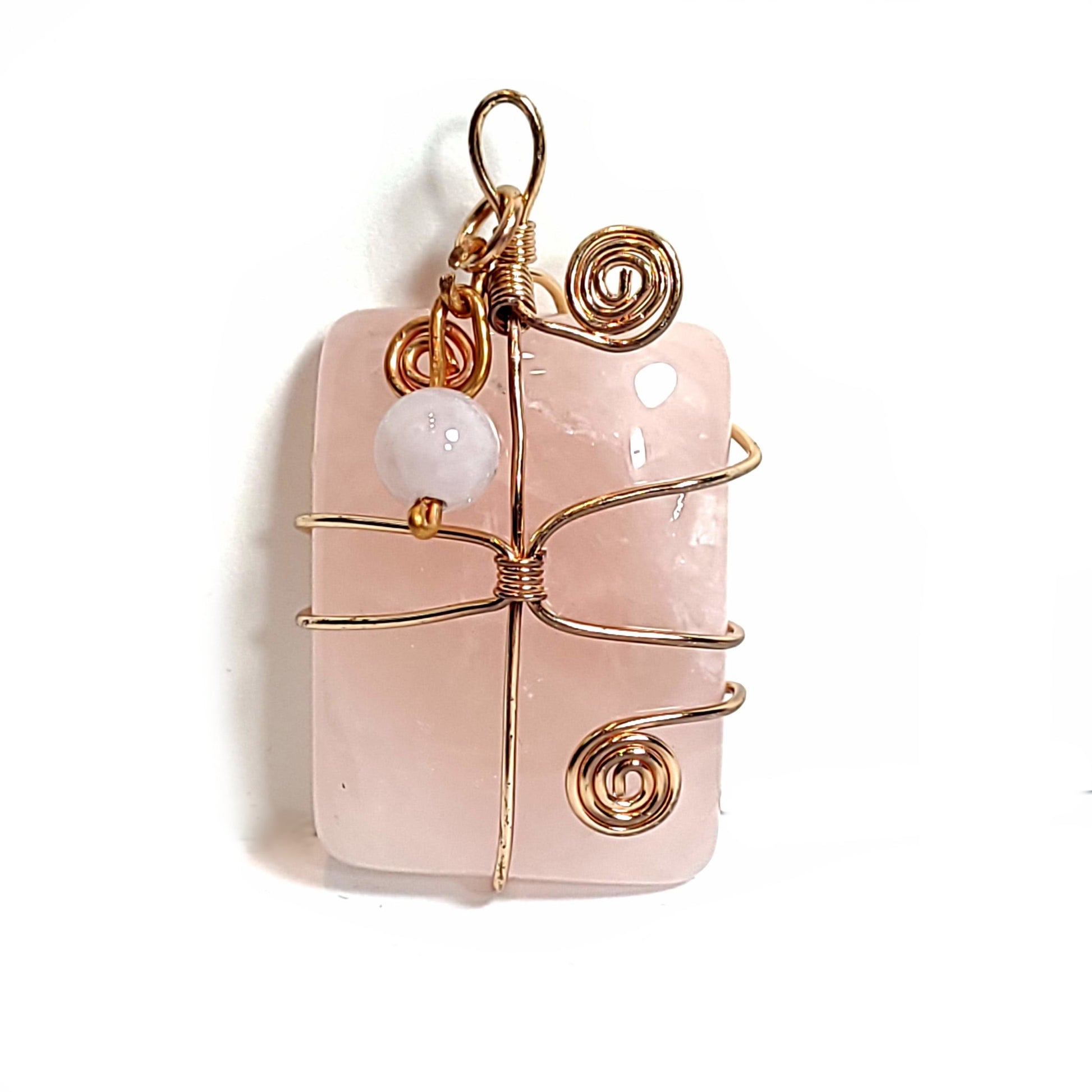 Rose quartz stone pendant wrapped with rose gold plated wire. Crowned with a rose quartz and distressed copper wire floating charm.