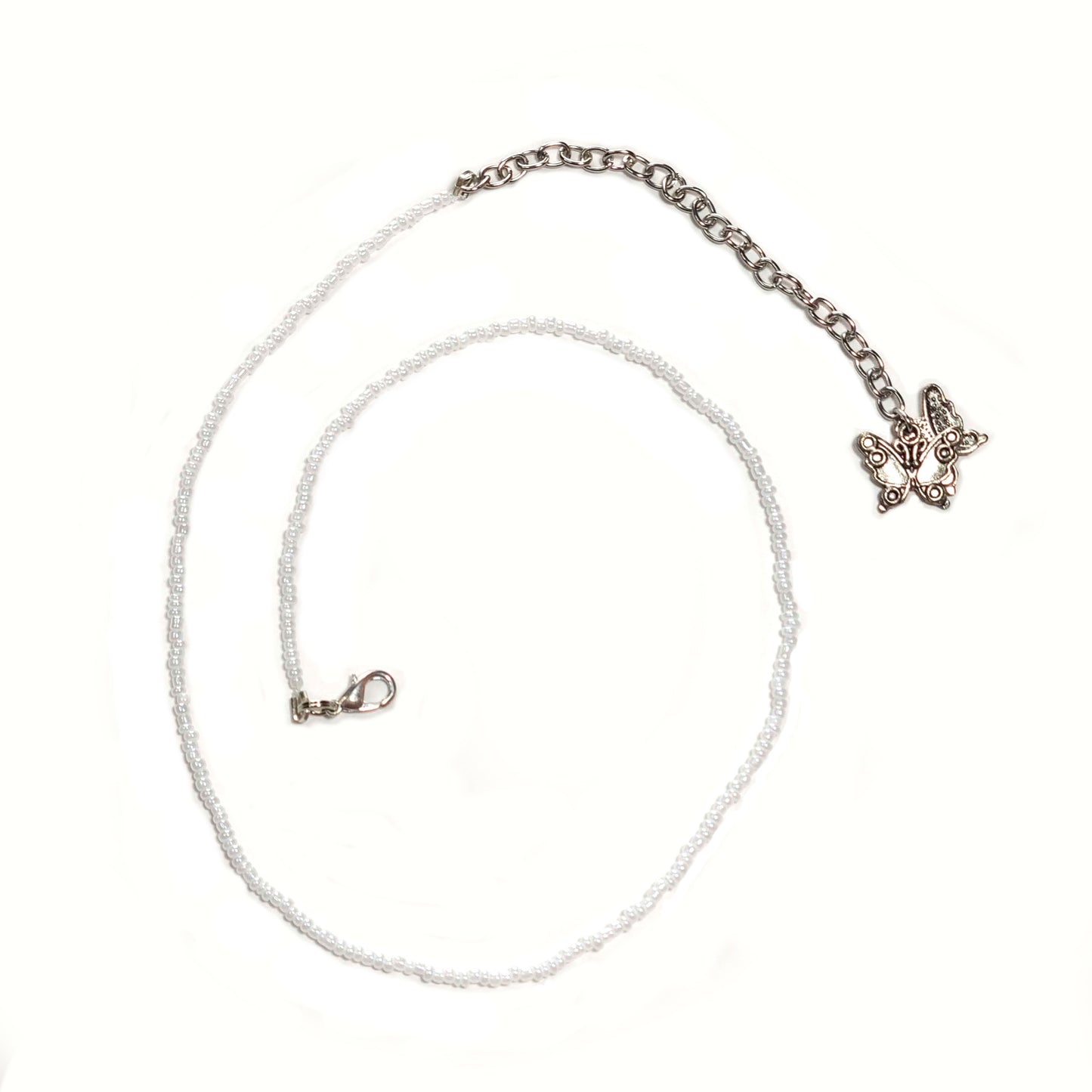 Single strand white seed bead necklace with an extender that has 2 butterfly charms on the end.