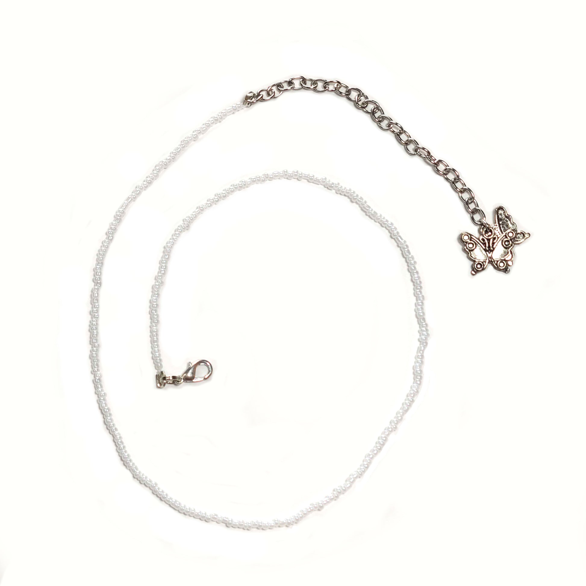Single strand white seed bead necklace with an extender that has 2 butterfly charms on the end.