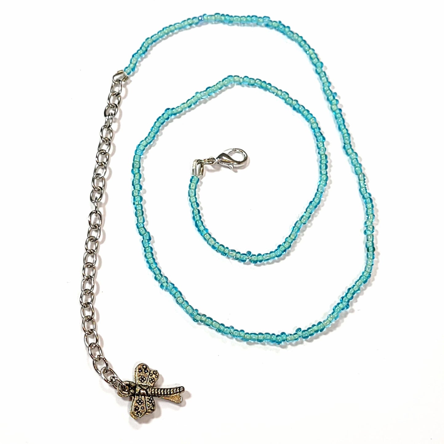Single strand light blue seed bead necklace with an extender that has 2 dragonfly charms on the end.