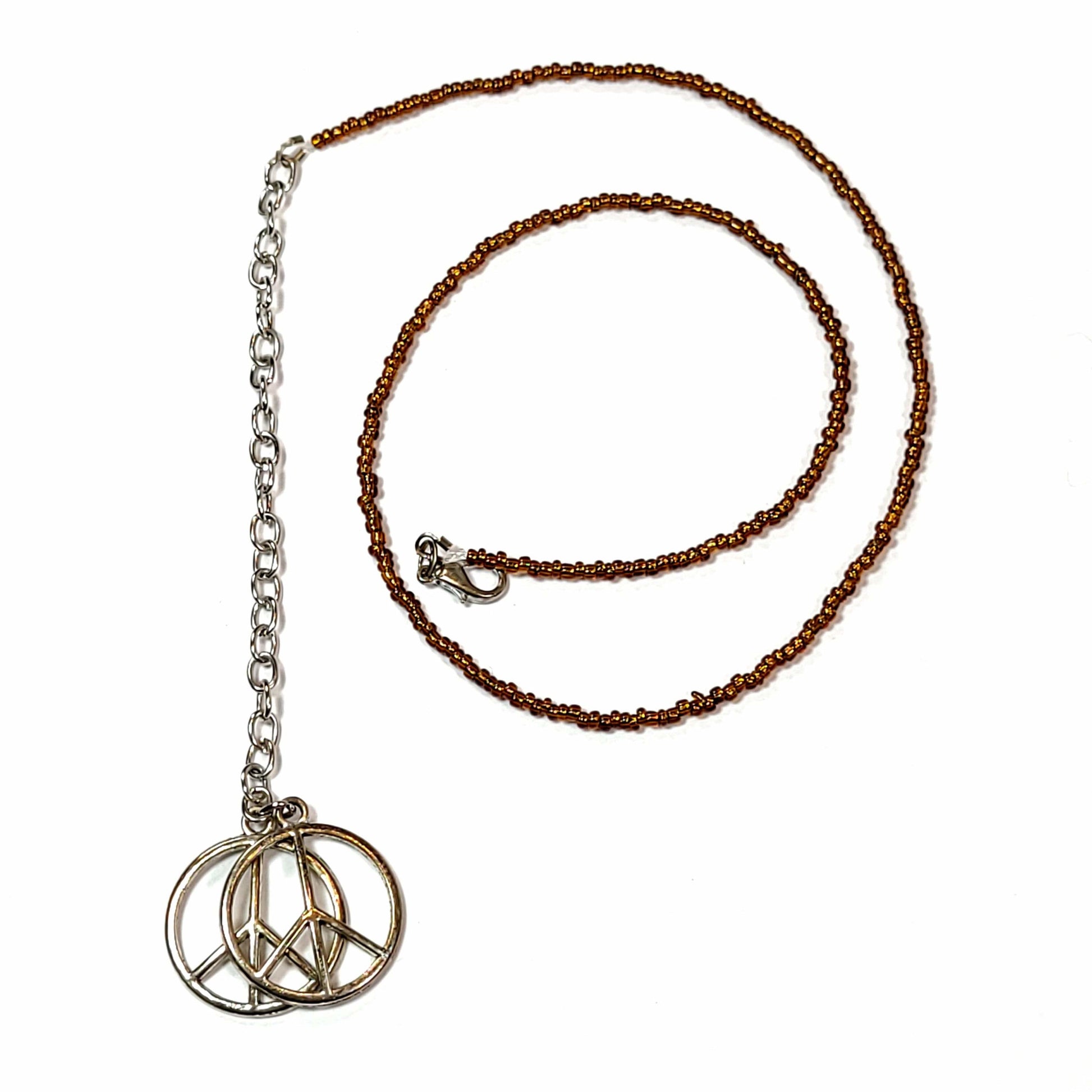 Single strand necklace made of brown seed beads with an extender that has 2 peace sign charms on the end.