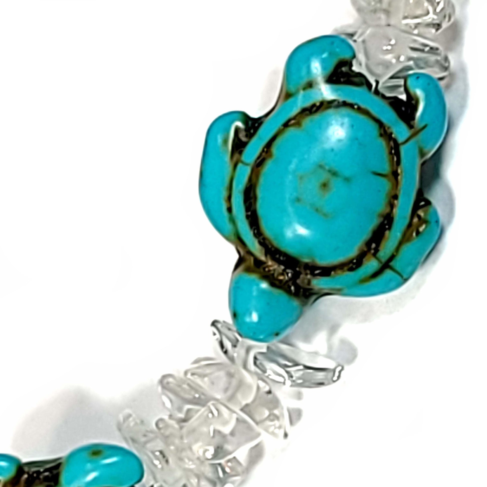 Close up view of a Bracelet made of Rose quartz chips and Howlite turtles with silver tone end caps, and lobster claw clasp.