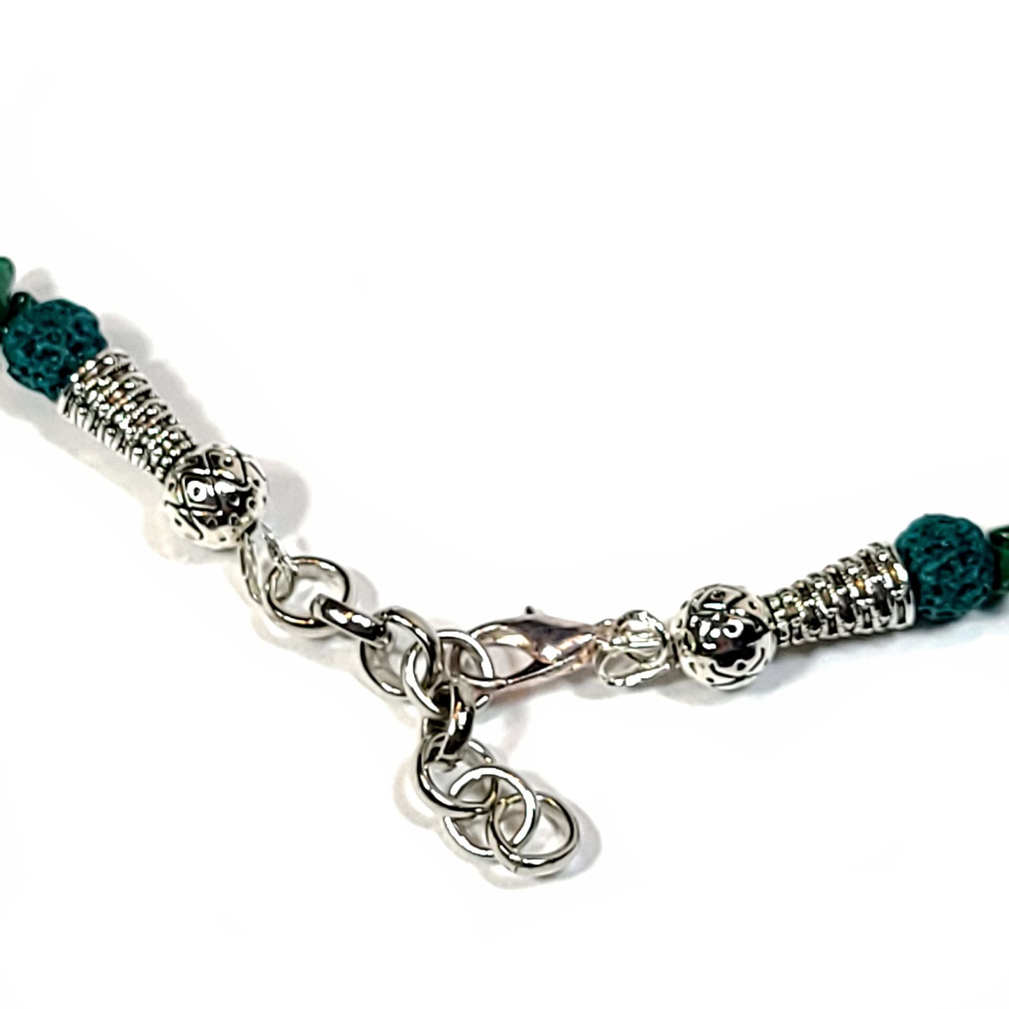 Close up of the clasp of a Necklace made of malachite chips, silver tone spacer beads, end caps and, toggle clasp.