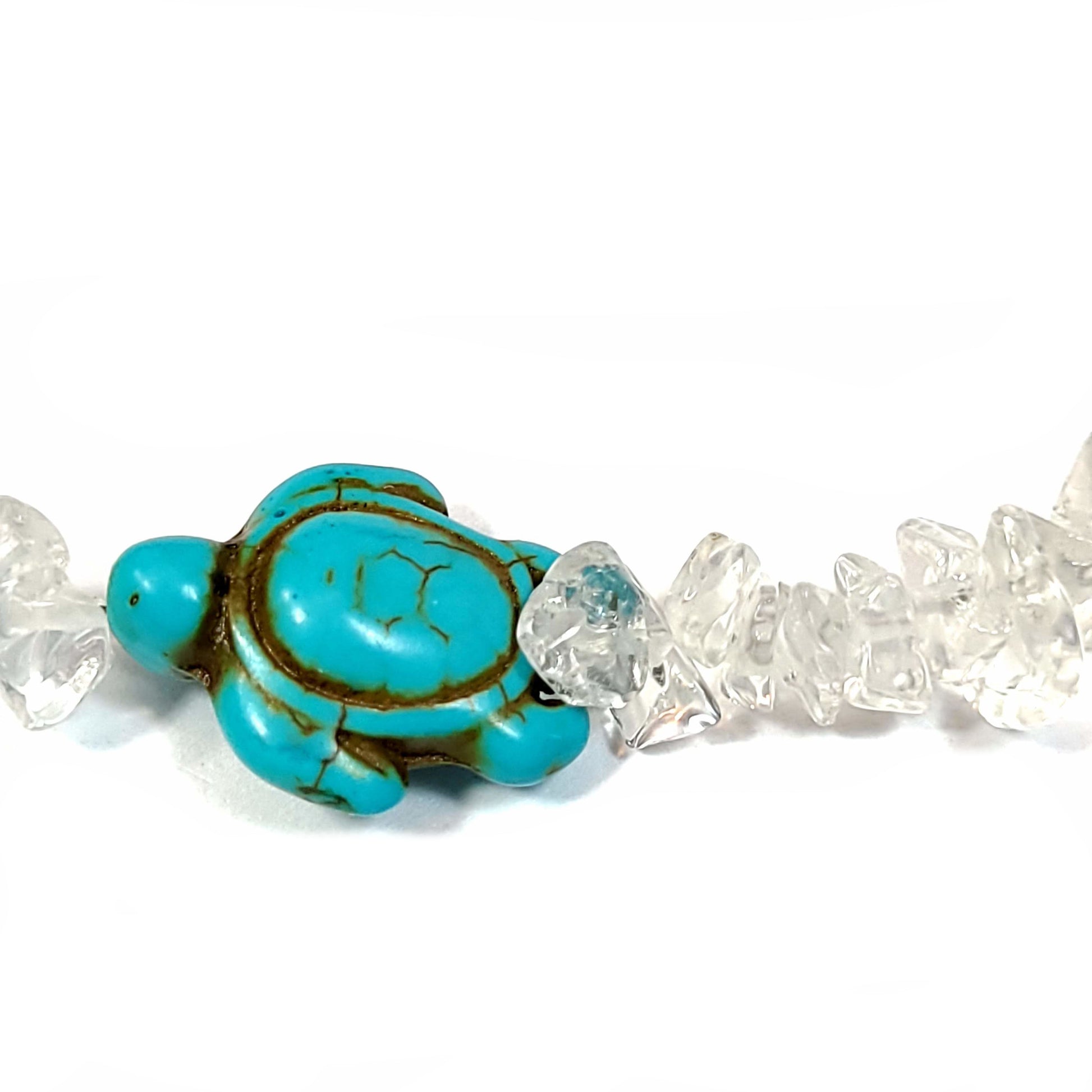 Close up view os a Necklace made of crystal quartz chips with aqua dyed howlite, and end caps with a silver tone extender chain and lobster clasp.